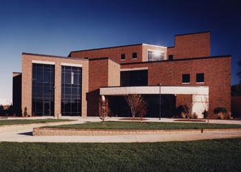 modern academic building with large windows and lawn